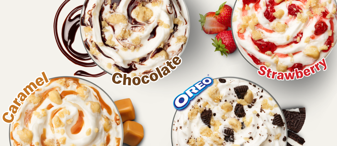 A top-down shot of four different McFlurry flavours, all with cheesecake-flavoured cookie dough pieces. One is labelled “Chocolate” and has chocolate syrup in it. One is labelled “Strawberry” and has strawberry syrup. One is labelled “Caramel” and has caramel syrup. The last is labelled “Oreo™” and has Oreo pieces in it.