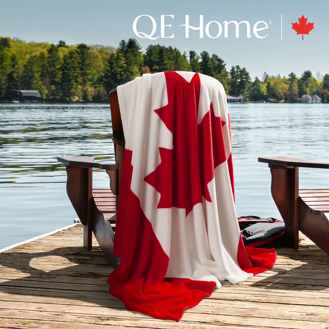 QE Home
There are two wooden chairs sitting on a dock. One of the chairs is covered in a blanket that resembles the Canadian flag.
