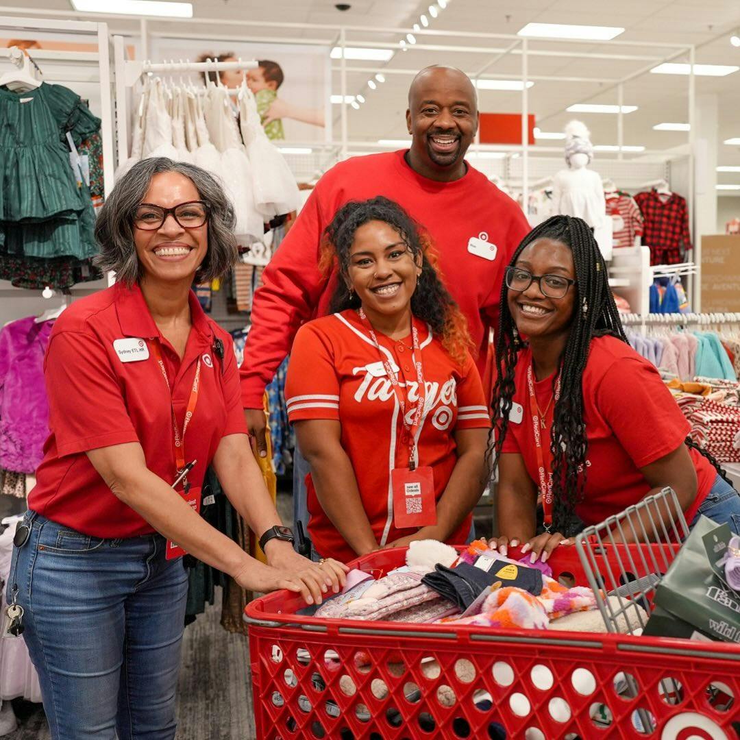 Group photo of Target employees with a full shopping cart